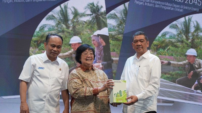 Pejabat menyerahkan buku Green Impact Days 2024 di atas panggung