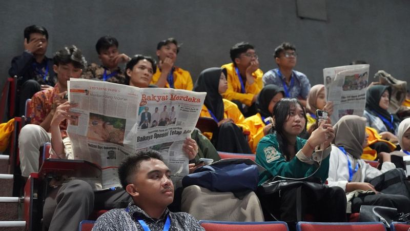 Peserta membaca koran di tribun Sabuga ITB